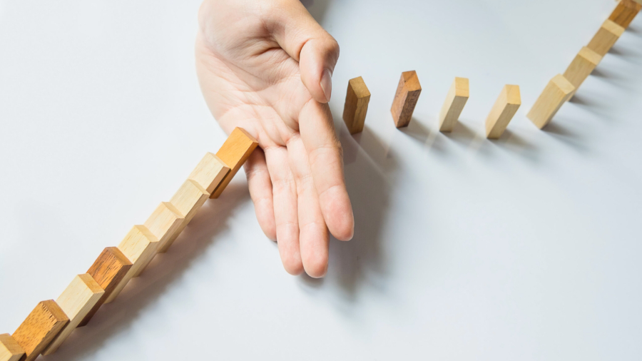 businessman hand stop dominoes continuous toppled or risk with copyspace